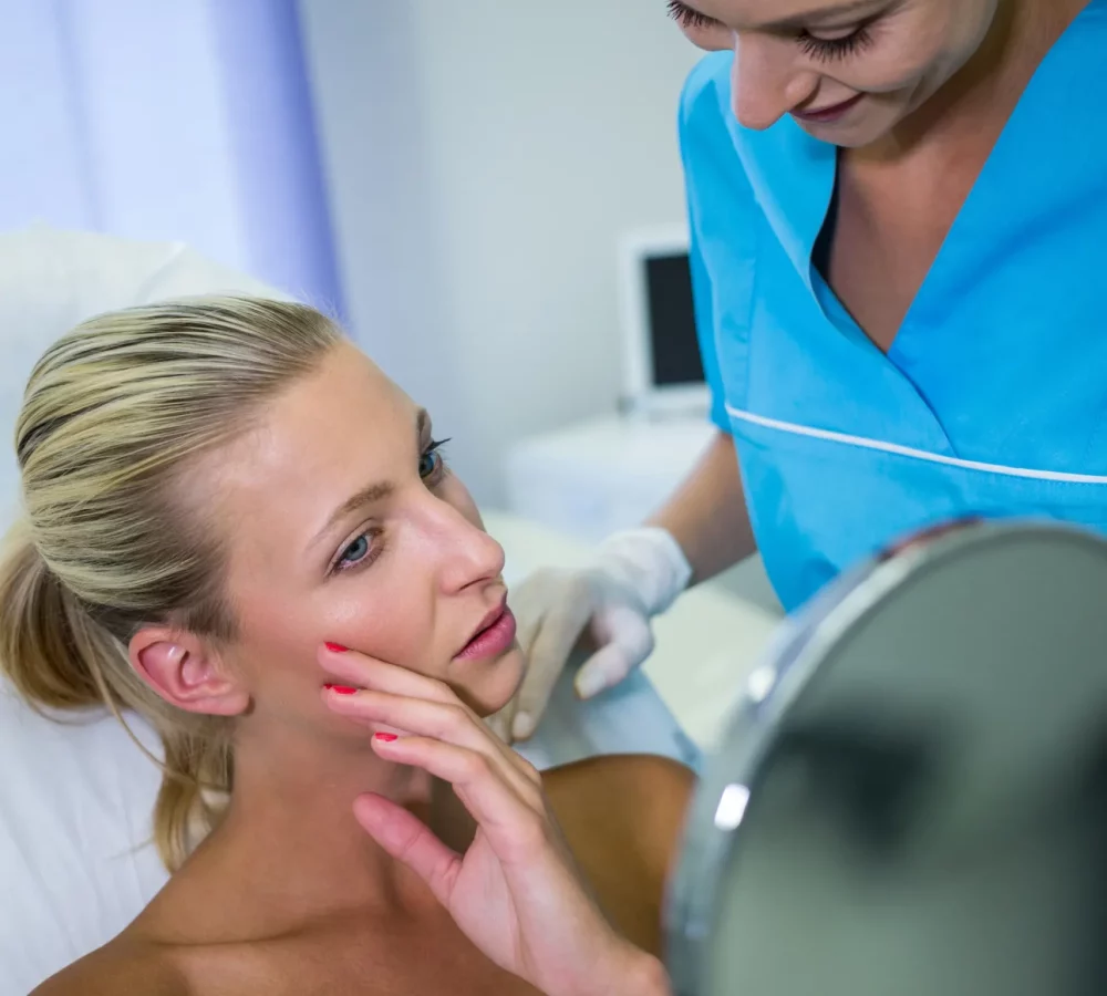 woman-checking-her-skin-mirror-after-receiving-cosmetic-treatment